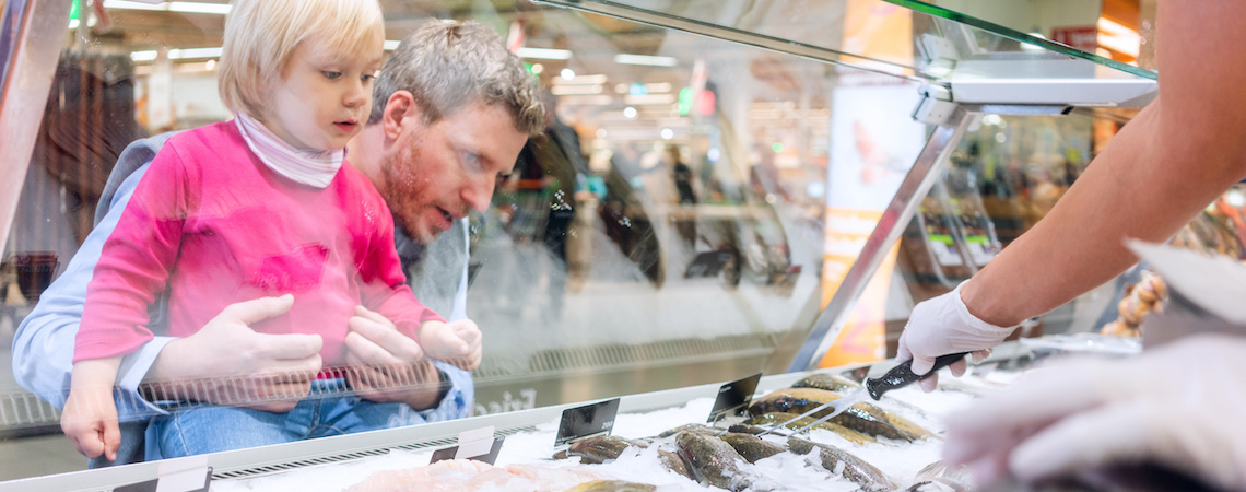 Parent and child looking at the fishmonger product display